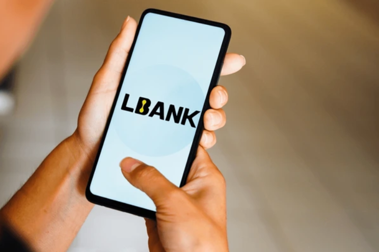 A person holding their phone with the LBank app running