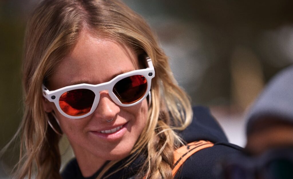 Check out the Oakley Meta HSTN! This stylish female wearer showcases the vibrant red-tinted lenses and white frame, perfect for outdoor adventures, though beware of potential grainy footage and dead battery issues. 😄